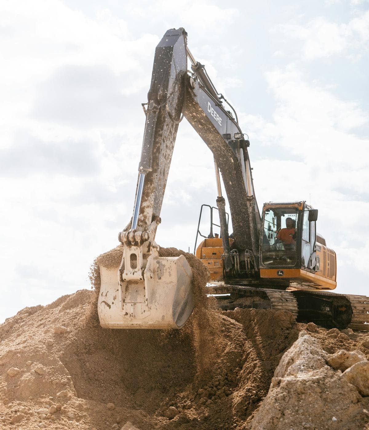A John Deere excavator moving earth